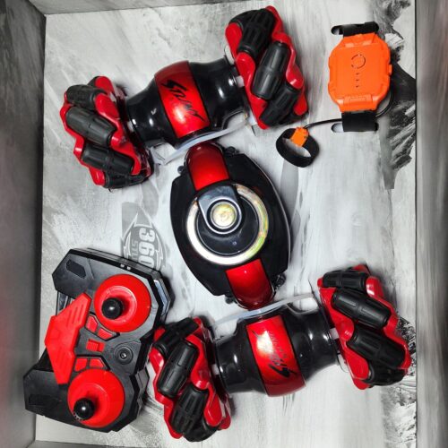 Red and black transforming RC stunt car disassembled with the traditional remote controller and the orange hand-gesture wristband. Khilone for Kids
