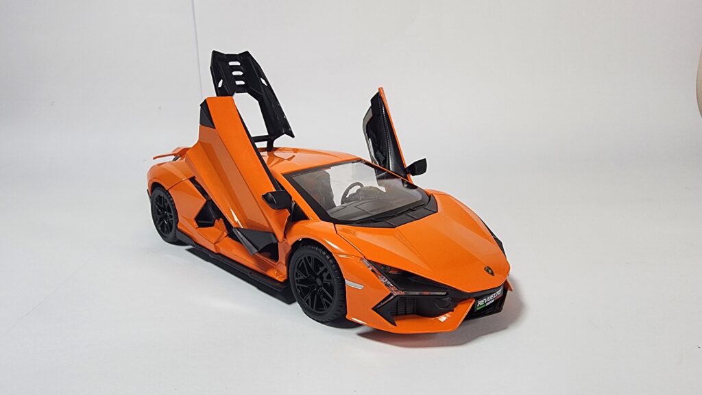 Bright orange 1:24 scale Lamborghini style hypercar die-cast model with its iconic scissor doors open, showing the aggressive front end and black wheels. Khilone for kids