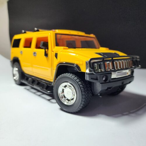 Bright yellow RC Hummer H2 style SUV truck model next to its black steering wheel remote controller, ready for play. Khilone for kids