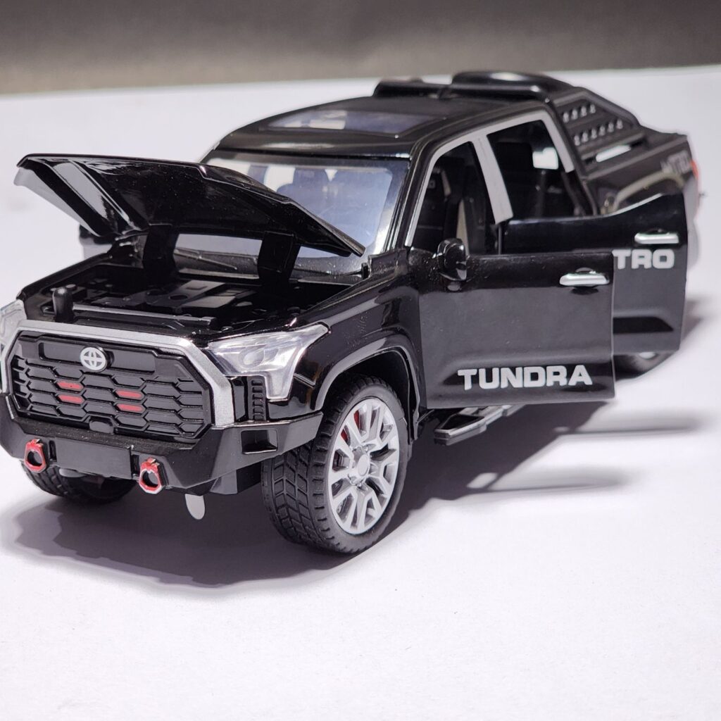 Black 1:32 scale Toyota Tundra TRD pickup truck die-cast model with all four doors, hood, and tailgate opened, showing the detailed interior and spare tire. Khilone for kids
